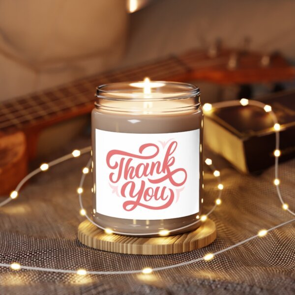 A close-up image of a 9oz custom label soy candle with a clear glass vessel. The candle label is beautifully designed with a user's artwork or inspirational quote. The candle wick is made of natural cotton.